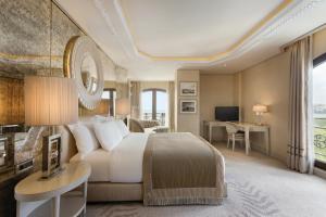 a bedroom with a bed and a desk and a television at Wyndham Grand Istanbul Kalamış Marina Hotel in Istanbul