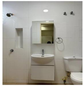 a white bathroom with a sink and a toilet at JM House Kuala Lumpur in Puchong
