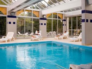 Un grupo de personas sentadas alrededor de una piscina. en ibis Sète Balaruc les Bains Bien-être et Spa, en Balaruc-les-Bains