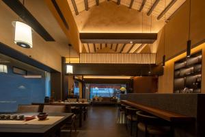 Un restaurante con mesas y sillas y un bar. en Changsha Pushe Minsu, en Changsha