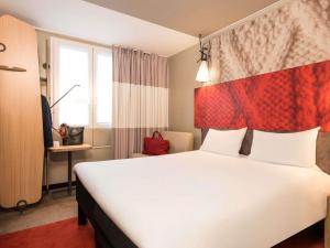 een hotelkamer met een groot bed en een raam bij ibis Paris Gare du Nord Château Landon 10ème in Parijs