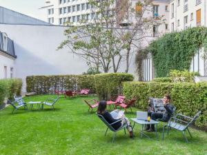 two people sitting in chairs in a yard at ibis Paris Gare de Lyon Ledru Rollin in Paris