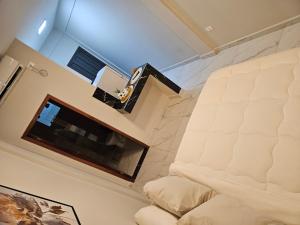 a bedroom with a white bed and a tv at Easy Access Apartment - Ciudad del Este in Ciudad del Este