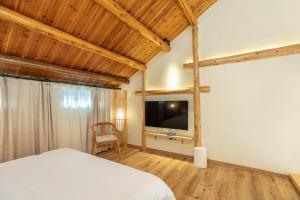 a bedroom with a bed and a flat screen tv at Shanghai Yipin Yijing B&B - Disney 上海一品艺景民宿-迪士尼店-近浦东国际机场 in Shanghai