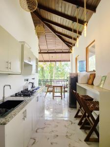 Una cocina con gabinetes blancos y una mesa con sillas. en Charisma Apartments, en Ahangama