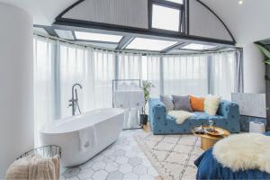 a bathroom with a large tub and a couch and a room with a couch at Shanghai Yipin Yijing B&B - Disney 上海一品艺景民宿-迪士尼店-近浦东国际机场 in Shanghai +88 photos