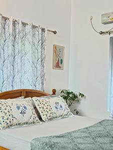 a bedroom with a bed with blue and white pillows at Harmonic Hideout in Varkala +32 photos