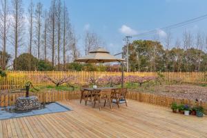 a wooden deck with a table and an umbrella at Shanghai Yipin Yijing B&B - Disney 上海一品艺景民宿-迪士尼店-近浦东国际机场 in Shanghai