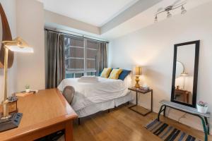 a bedroom with a bed and a desk and a mirror at Luxury 1-Bedroom Condo in Yorkville, Downtown Toronto in Toronto