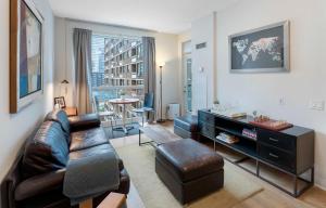 a living room with a leather couch and a table at Luxury 1-Bedroom Condo in Yorkville, Downtown Toronto in Toronto