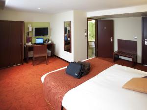 a hotel room with a bed with a bag on it at Mercure Strasbourg Centre Gare in Strasbourg