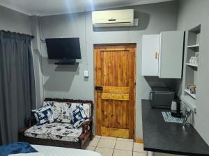 a room with a door and a couch and a television at WegkruiperQ in Beaufort West