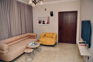 a living room with a couch and a chair and a television at Four Stays Khobar in Al Khobar