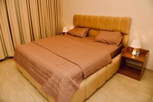 a large bed in a room with a side table at Four Stays Khobar in Al Khobar +12 photos