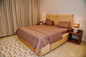 a bedroom with a large bed and two night stands at Four Stays Khobar in Al Khobar