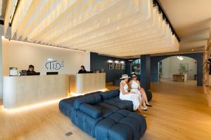 a group of people sitting on a couch in a lobby at Hotel Tide Phuket Beachfront in Phuket Town