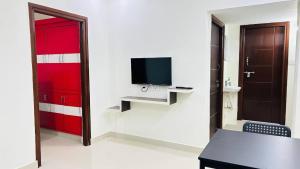 a room with a red door and a desk and a tv at 1 BHK Near AIG Hospital Sai Castle Serviced Apartment in Kondapur +10 photos
