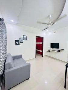 a living room with a couch and a tv at 1 BHK Near AIG Hospital Sai Castle Serviced Apartment in Kondapur