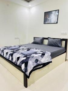 a bedroom with a bed with a black and white comforter at 1 BHK Near AIG Hospital Sai Castle Serviced Apartment in Kondapur