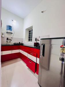 a kitchen with red and white cabinets and a refrigerator at 1 BHK Near AIG Hospital Sai Castle Serviced Apartment in Kondapur
