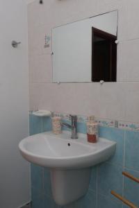 a bathroom with a white sink and a mirror at Kaz mahury zen-wifi-climatisation in Rémiré