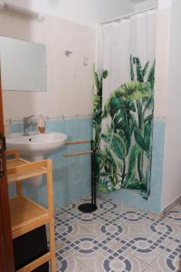 a bathroom with a shower curtain with a sink at Kaz mahury zen-wifi-climatisation in Rémiré