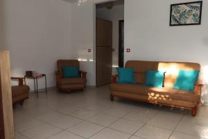a living room with two couches and two chairs at Kaz mahury zen-wifi-climatisation in Rémiré