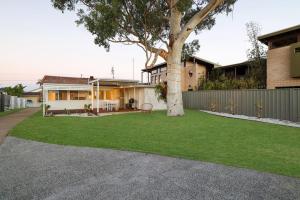 a house with a tree in the yard at Casa Esperanza by Experience Jervis Bay in Vincentia +8 photos