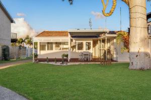 a white house with a lawn in front of it at Casa Esperanza by Experience Jervis Bay in Vincentia