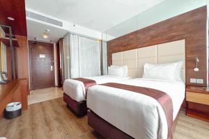 Postel nebo postele na pokoji v ubytování Asialink Hotel Batam by Prasanthi