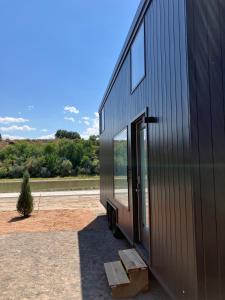 a black building with a large glass door on the side at Secluded Tiny House Oasis in Grand Junction: Nature's Perfect Glamping Hideaway in Colorado in Grand Junction