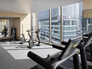 a gym with cardio machines and a large window at Hotel Hankyu GRAN RESPIRE OSAKA in Osaka