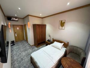 a hotel room with a bed and a chair at Muhammad in Andizhan