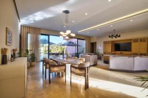 a dining room and living room with a table and chairs at Villa Marrakech in Marrakesh