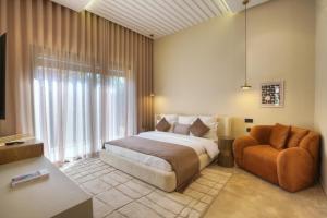 a bedroom with a bed and a chair at Villa Marrakech in Marrakesh