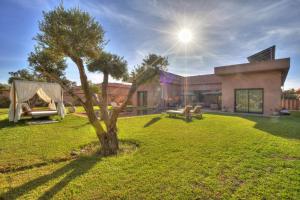 a house with a tree in the yard at Villa Marrakech in Marrakesh