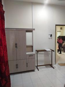 een kamer met een houten kast en een tafel bij Teratak Desa Cemerlang 1 