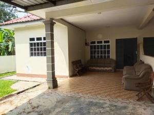 een woonkamer van een huis met een bank bij Teratak Desa Cemerlang 1 