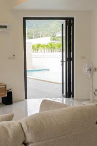 een woonkamer met een bank en een grote glazen schuifdeur bij casa aviv villa in Nathon Bay