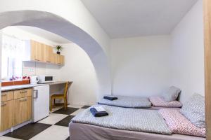 a kitchen with a bed and a table in a room at Penzion 43 in Bor