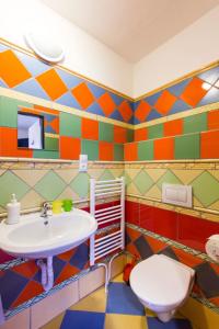 La salle de bains colorée est pourvue d'un lavabo et de toilettes. dans l'établissement Penzion 43, à Bor