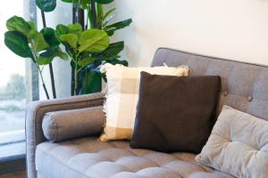 a couch with pillows on it in a living room at Southbank exceptional View with huge balcony High Lvl Suite style APT in Brisbane