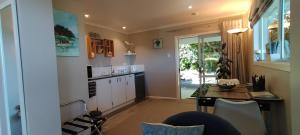 a kitchen with a table and a dining room at Bird Haven in Coromandel Town