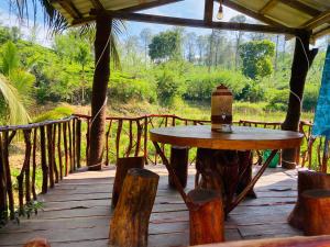 a wooden deck with a table and a lantern on it at Nine arch eco Villa Ella in Ella