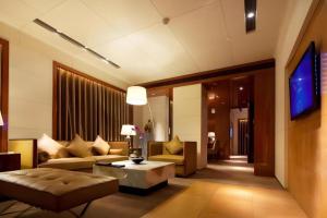 Una sala de estar con un sofá y un televisor. en Hotel Leader Changsha, en Changsha
