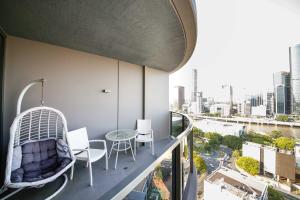 a balcony with a table and chairs on a building at Southbank exceptional View with huge balcony High Lvl Suite style APT in Brisbane