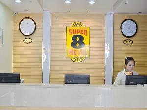 a woman sitting at a desk in an office at Super 8 Hotel Jinan Railway Station Square in Jinan