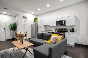ピッツバーグにあるCozySuites Stunning 1BR in Downtown Pitts 12のソファとキッチンのあるリビングルーム