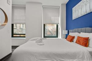 ピッツバーグにあるCozySuites Stunning 1BR in Downtown Pitts 12のベッドルーム1室(大きな白いベッド1台、窓2つ付)
