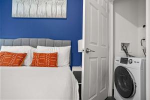 ピッツバーグにあるCozySuites Stunning 1BR in Downtown Pitts 12の青い壁のベッドルーム1室、ベッド1台(オレンジ色の枕付)